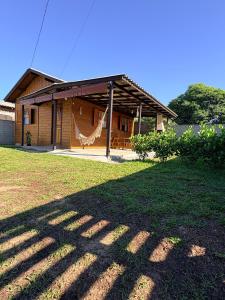 a house with a hammock in front of it at Casa aconchegante inteira - Casa por Dia Imbituba SC in Imbituba