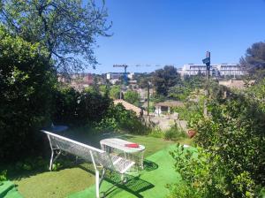 a white bench sitting on the grass in a yard at Ingrid Mary in Nîmes