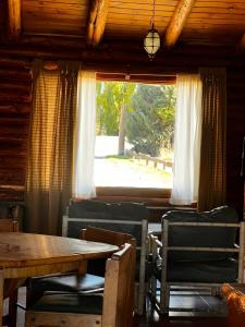 a dining room with a table and chairs and a window at cabaña Quovadis in Trevelín