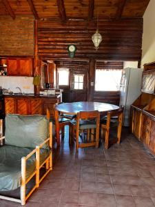 a kitchen with a table and chairs in a room at cabaña Quovadis in Trevelín +2 photos