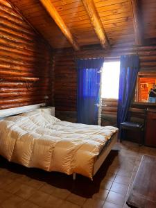 a bedroom with a bed in a log cabin at cabaña Quovadis in Trevelín