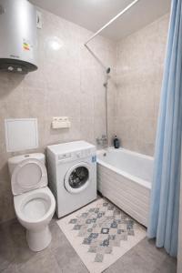 a bathroom with a toilet and a washing machine at Happy House in Karagandy +80 photos