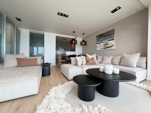 a living room with two couches and a table at NEPTUNE Wenduine met zeezicht - VOSPROPERTIES in Wenduine