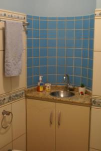 a bathroom with a sink and a blue tiled wall at recanto do paraiso in Penha +25 photos