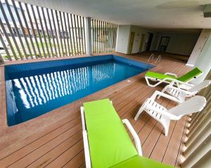 a deck with chairs and a swimming pool at Veron, Dzorwulu in Accra