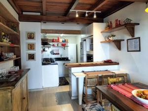 a kitchen with white walls and wooden ceilings and a table at recanto do paraiso in Penha