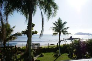a view of the beach from a resort with palm trees at recanto do paraiso in Penha