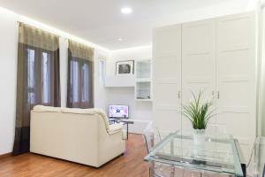 sala de estar con sofá blanco y mesa de cristal en For You Rentals Plaza Dos de Mayo Apartment DP13, en Madrid