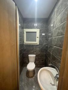 a bathroom with a toilet and a sink at Egy property in 6th Of October +8 photos
