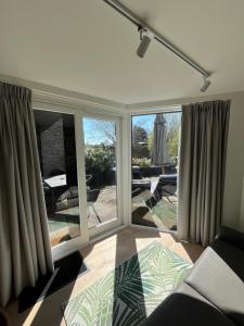 a living room with large windows and a view of a patio at Business Accommodation 'Garden' Living Intimate in Geel