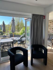a living room with chairs and a large window at Business Accommodation 'Garden' Living Intimate in Geel