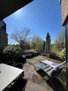 a patio with a table and chairs and an umbrella at Business Accommodation 'Garden' Living Intimate in Geel