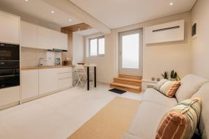 a living room with a couch and a kitchen at The Urban Core at Corfu Center! in Corfu