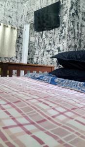 a bedroom with a bed and a tv on the wall at Chale mundo da Lua 2 in Piedade