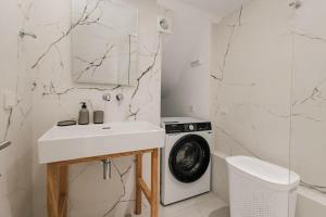 a white bathroom with a washing machine and a sink at The Urban Core at Corfu Center! in Corfu