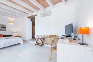 a room with a bed and a desk with a television at Hotel Moscari Nature & Wellness by CheelHotels in Moscari +38 photos