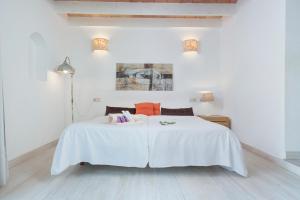 a white bedroom with a white bed with orange pillows at Hotel Moscari Nature & Wellness by CheelHotels in Moscari