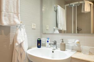 a white bathroom with a sink and a mirror at Hotel Altstadt in Erlach +89 photos