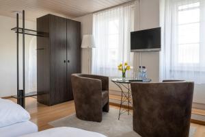 a bedroom with a table and chairs and a bed at Hotel Altstadt in Erlach