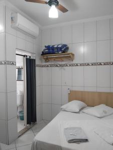 a bedroom with a bed and a ceiling fan at Pousada Soares in Aparecida