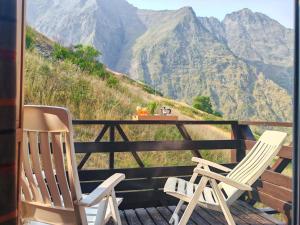 two chairs sitting on a deck with mountains in the background at Le Cozy in Aragnouet
