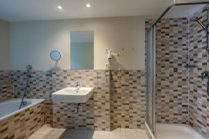 a bathroom with a sink and a shower and a tub at Premier Inn Berlin City Spittelmarkt in Berlin +20 photos