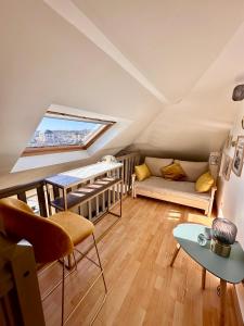 a attic living room with a couch and a table at Le Champlain Duplex Port de plaisance in Dieppe
