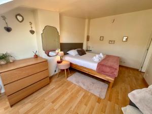 a bedroom with a bed and a dresser with a mirror at Le Champlain Duplex Port de plaisance in Dieppe