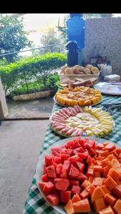 a table with plates of fruit on a table at POUSADA GRACAS in Cachoeira Paulista
