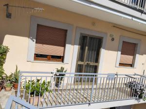 a house with a balcony with plants and windows at Civico 47 in Ogliastro Cilento