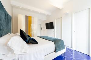 a bedroom with a white bed with blue pillows at La Suite Del Cavaliere in Amalfi