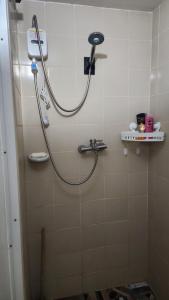 a shower with a hose in a bathroom at Condo Minsorado in General Trias