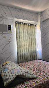 a bedroom with a bed and a window with a curtain at Condo Minsorado in General Trias