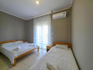 a bedroom with two beds and a window at Europa Hotel Korinos in Korinos
