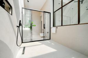 a bathroom with a shower and a glass door at Casa Del Mare Ocean SeaView Villa with Private Pool in Zanzibar City