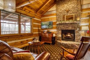 a living room with a fireplace in a log cabin at Pipers Place in Townsend