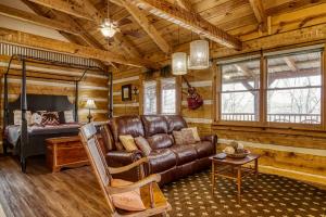 a living room with a leather couch and a bed at Pipers Place in Townsend +23 photos
