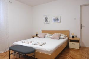 a bedroom with a bed and a chair at Apartments Marsela in Tučepi