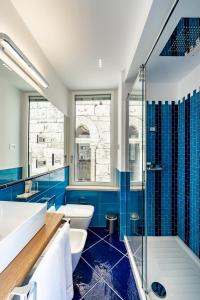 a bathroom with blue tiles and a tub and a sink at La Suite Del Cavaliere in Amalfi +66 photos