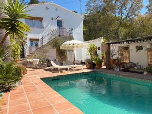 a swimming pool in front of a house at Casa Tragabalas in Cómpeta