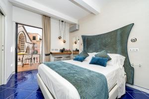 a bedroom with a large bed with blue pillows at La Suite Del Cavaliere in Amalfi
