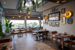 a dining room with tables and chairs in a restaurant at The Waterside Hotel & Spa in Seamill