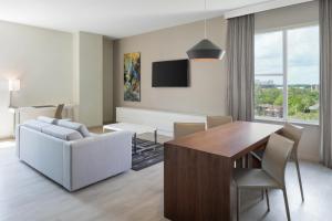 a living room with a dining room table and a couch at AC Hotel by Marriott Gainesville Downtown in Gainesville