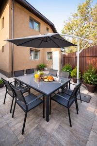 a black table with chairs and an umbrella at Residence by DANIA & PETRU in Târgu Ocna