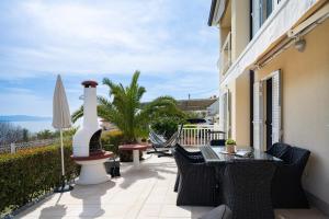 a patio with a table and chairs and an umbrella at Apartment Paradiso - Ravni in Labin +15 photos