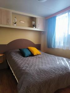 a bedroom with a bed with a yellow and blue pillow at La Dolce 1 in Lido di Dante +26 photos