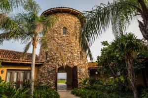 a stone building with an archway and palm trees at Royal Isabela in Isabela