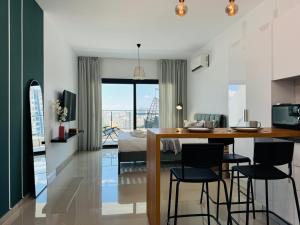 a kitchen and living room with a bed and a table at Nothern Cyprus Caesar Resort & Spa Collection Pools & Long Beach in Aglantzia