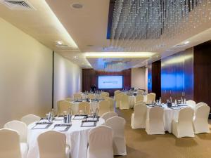 a conference room with white tables and chairs and a projection screen at Southern Sun Abu Dhabi in Abu Dhabi +101 photos