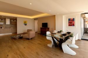 a dining room and living room with a table and chairs at Maison de Charme Taormina with private jacuzzi in Taormina